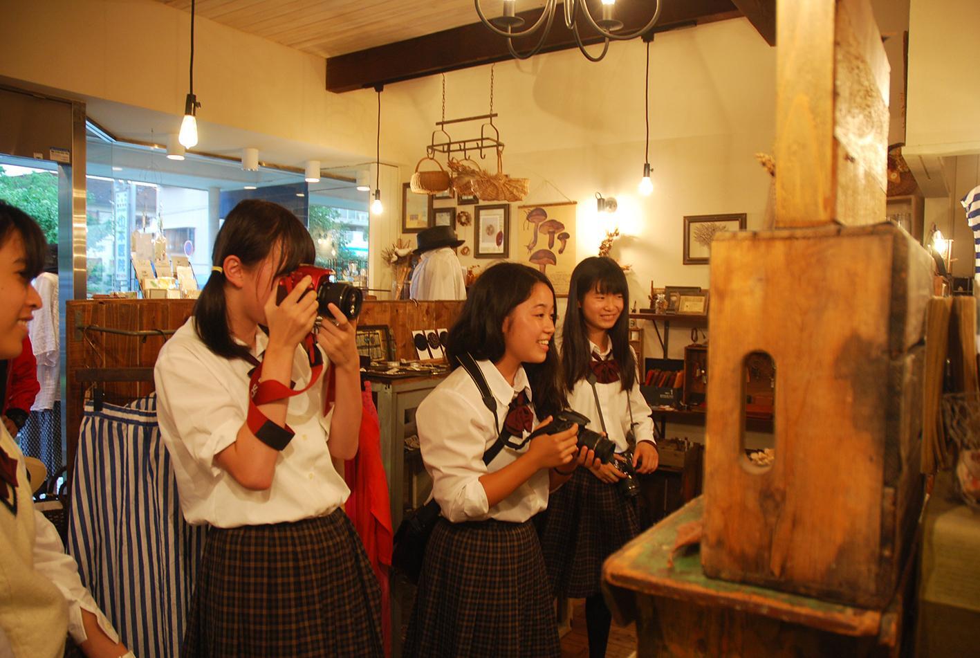 生野高校写真部が店内で写真を撮っている写真