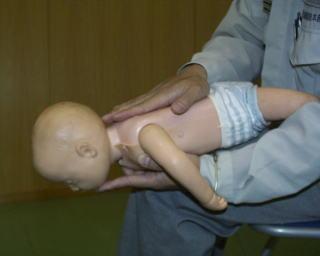 乳児に対する気道異物除去（背部叩打法）の写真